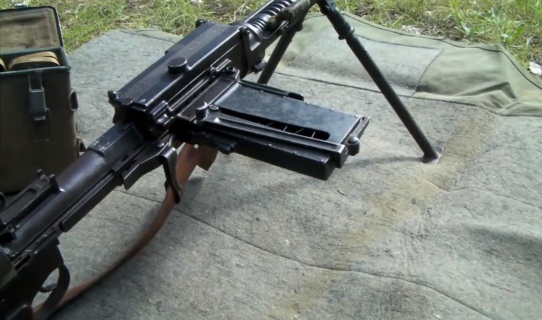 布雷达m30轻机枪的侧置弹仓从弹药箱内取出装满枪弹的桥夹向前翻折
